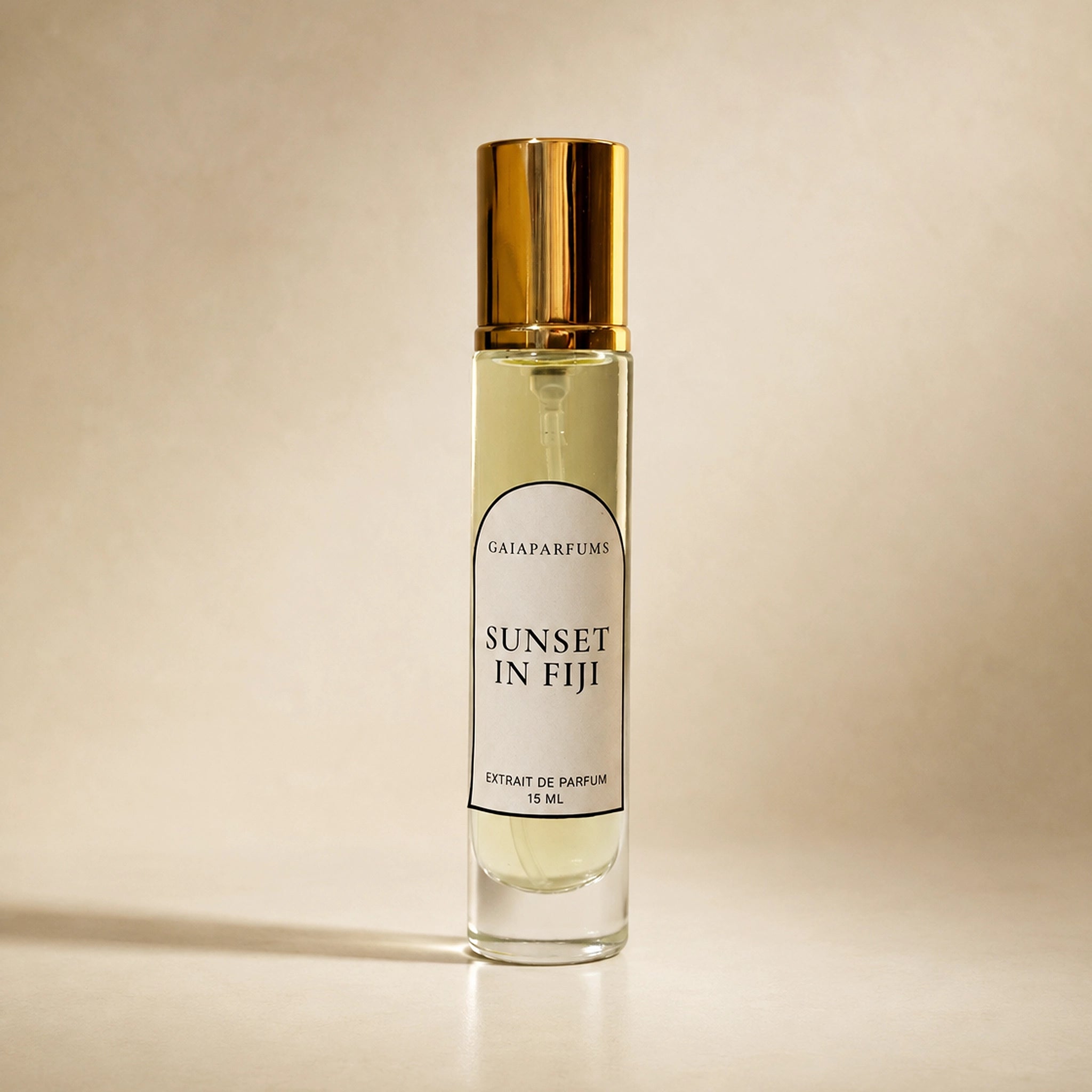 A 15 mL clear glass perfume bottle with a reflective gold cap, labeled 'SUNSET IN FIJI' by GAIA Parfums, set against a warm beige background.
