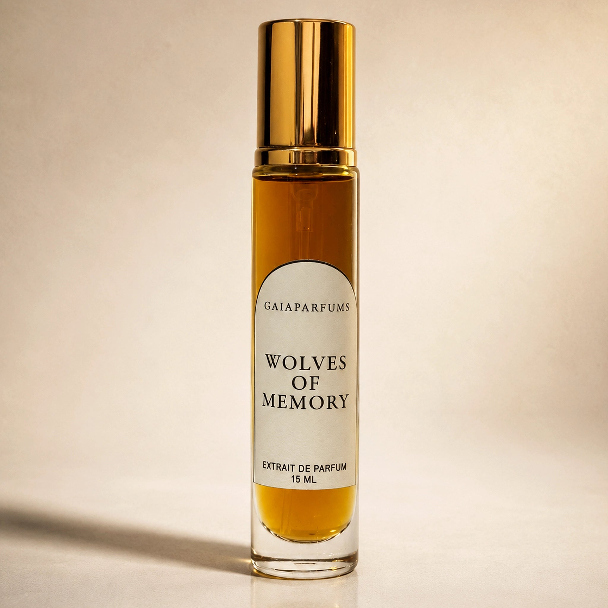 A 15ml glass bottle of GAIA Parfums 'Wolves of Memory' extrait de parfum, featuring a reflective gold cap and a white label, set against a warm beige background.